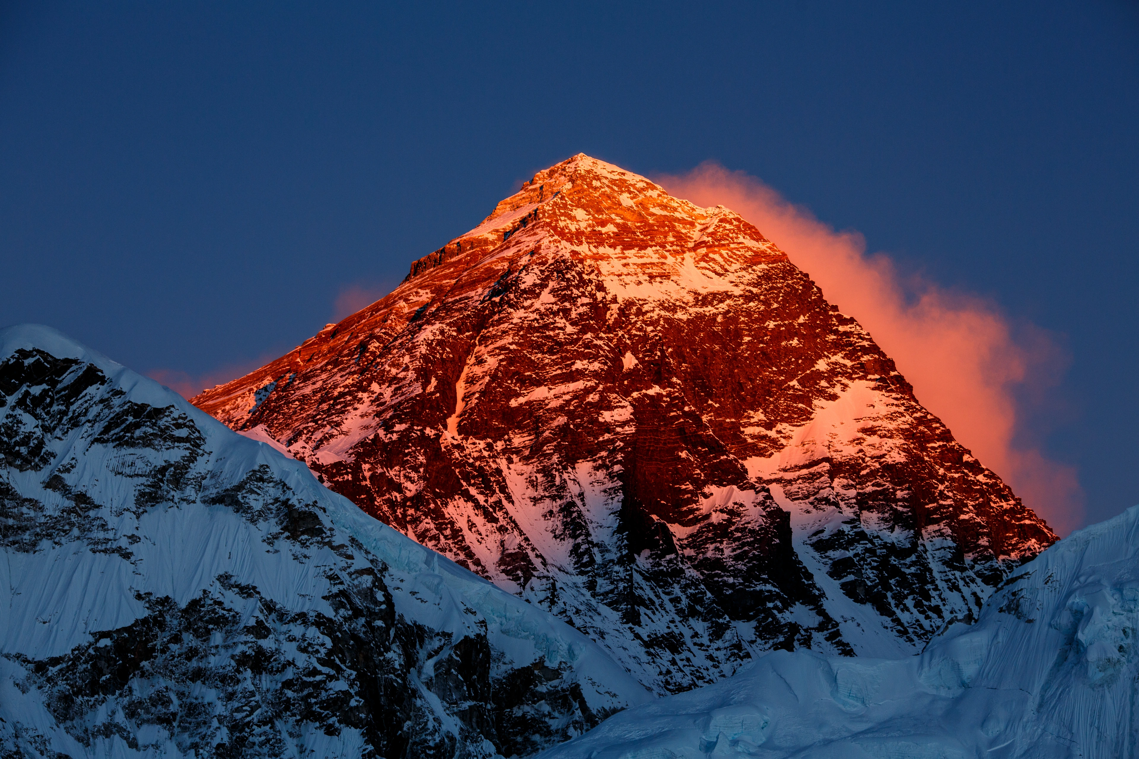 Warm alpenglow on a snow-covered mountain summit.