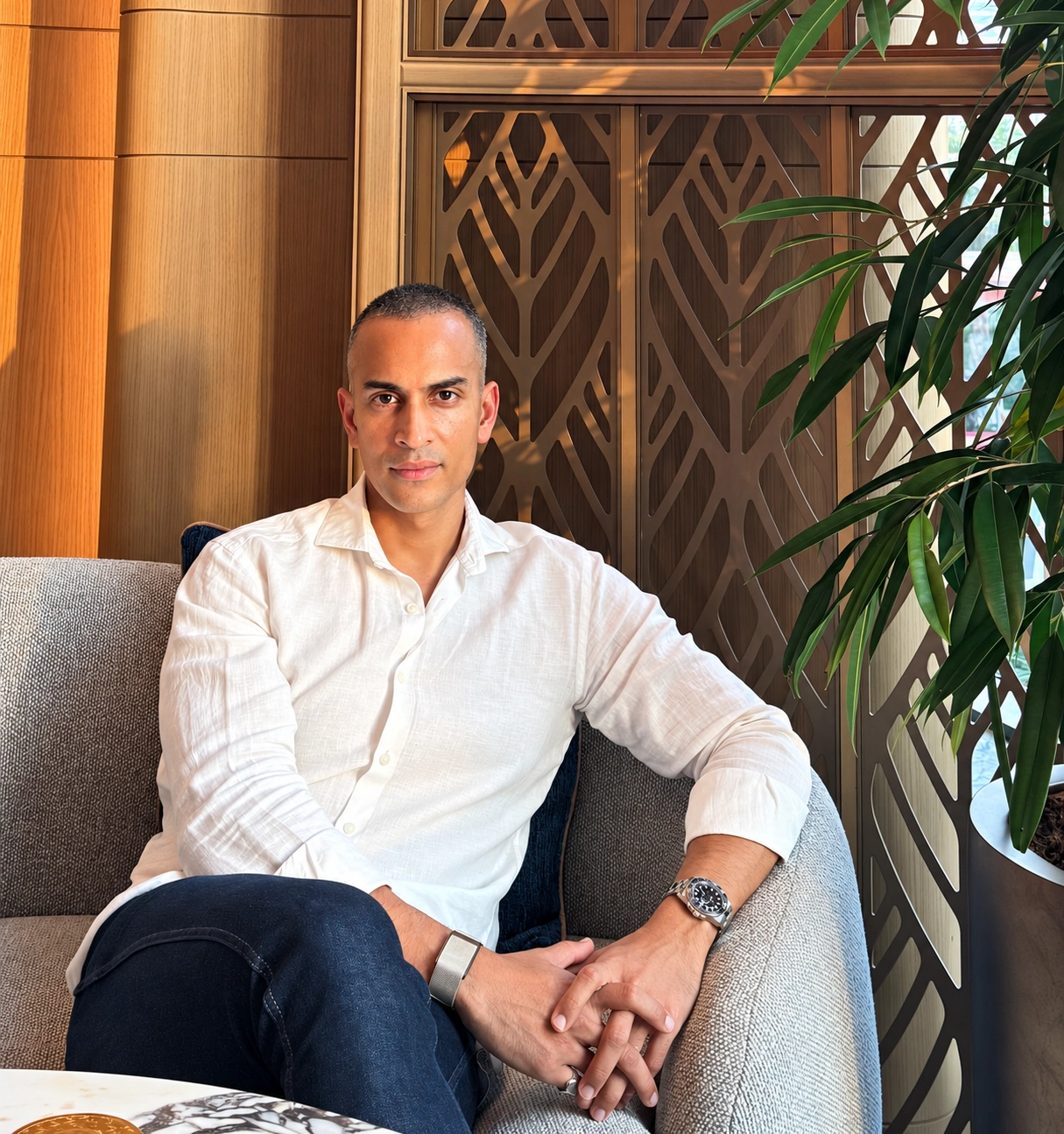 Yusuf Ameer seated in a warm, naturally lit interior.
